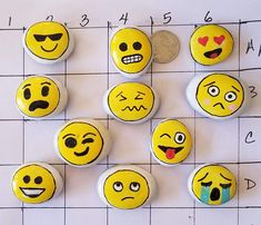 nine buttons with different faces on them sitting next to a penny and some type of coin