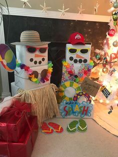 two snowmen are standing next to each other in front of a christmas tree and presents