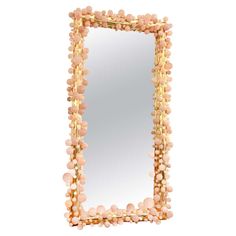 a mirror that has beads on it and is in the shape of a frame with gold trim