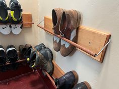 several pairs of shoes are hanging on the wall in a shoe rack with two hooks