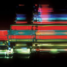 an abstract photograph of colorful lights on the side of a truck at night with long exposure