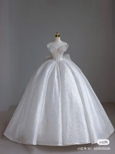 a white wedding dress on display in front of a gray background with the words,