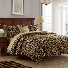 a leopard print comforter set in a bedroom with a lamp on the side table