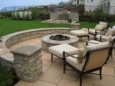 an outdoor fire pit surrounded by chairs