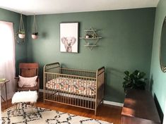 a baby's room with green walls and wooden floors