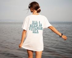 Embrace the ocean-inspired style with our "All I Need is Vitamin Sea" shirt, perfect for anyone who craves the Southern beachy vibes. Whether you're lounging by the shore or catching waves, this Vitamin Sea shirt will keep you stylish and connected to the sea. All designs are available on t-shirts, sweatshirts, and hoodies. Feel free to send me a message if you can't find the product you need! MATERIAL This t-shirt is soft and has the perfect amount of stretch. It is flattering and comfortable f Casual Ocean Color Beach Tops, Casual Ocean Color Tops For Beach, Summer Cotton T-shirt For Ocean Activities, White Tops For Ocean Activities In Summer, Cotton T-shirt For Summer Ocean Activities, I Need Vitamin Sea, Beachy Vibes, Surf Shirt, Vitamin Sea