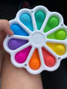 a person holding an ice cream mold in their left hand and colorful popsicle molds in the middle