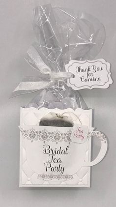 a white tea bag filled with cake in it's packaging next to a tag that says bridal tea party