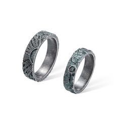 two silver rings with intricate designs on them