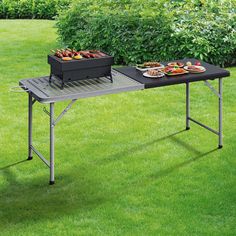 two trays of food sit on top of a table in the middle of grass