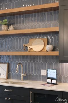 a kitchen counter with wooden shelves above it