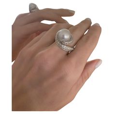 This ring elegantly embodies the dynamic essence and strength of a spiral in its design. This gesture raises a perfect South-Sea pearl on your fingers and illuminates them with diamonds. Meticulously crafted in 18K white gold, this exquisite ring features a lustrous Australian pearl weighing 12.75 carats, gracefully positioned at the heart of the spiraling design. The total weight of the ring is 14.60 grams, adding a substantial yet comfortable presence to your hand. The pavé setting, adorned wi Luxury Sterling Silver Pearl Drop Ring, Sea Pearl, Twist Ring, Pave Setting, South Seas, South Sea Pearls, Sea Pearls, Pearl Diamond, Beaded Rings