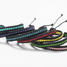 several different colored bracelets on a white background