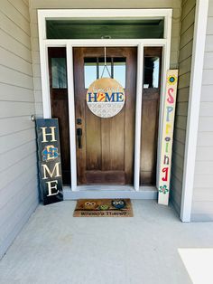 the front door of a home with welcome signs on it and a welcome mat in front