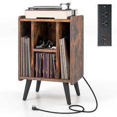 an old record player is plugged into the side of a wooden shelf with vinyl records