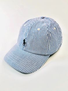 This Polo Ralph Lauren seersucker hat is a clean perfect casual warm weather stylish cap.   DETAILS: Seamed bill. Six-panel construction. Embroidered ventilating grommets. Signature embroidered pony at the front Embroidered "Polo" and a slider buckle at the back. 23 ¼” inner circumference. 98% cotton, 2% elastane. Imported. PAYMENT I accept PayPal payments. Please pay as soon as the auction is finished or I will cancel the winning bid. If you don't plan on paying, please hold back from bidding.  Our service is to get the item to the buyer as quickly as possible and do not want non-paying bidders to bid. All our items are genuine, 100% authentic. We spend a-lot of time, and work very hard getting these items. We are honest, and list items accurately in our pictures and descriptions.  Please Navy Spring Cap, Classic Blue Baseball Cap For Spring, Classic Blue Baseball Cap For Summer, Adjustable Striped Baseball Cap, Casual Striped Adjustable Baseball Cap, Striped Cotton Cap, Striped Cotton Casual Hat, Casual Striped Cap, Summer Baseball Cap With Embroidered Logo And Short Brim