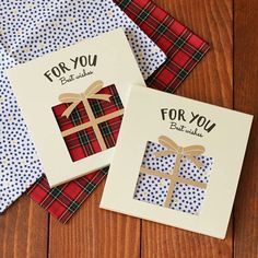 three cards with gift boxes on them sitting on top of a wooden table next to each other