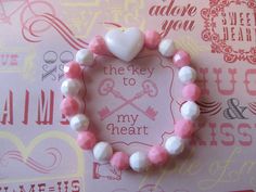 This is a Valentine Heart Beaded Bracelet. It has a white pearl heart pony bead in the middle. It has white and pink solid 8mm faceted beads. It was made with .8mm sturdy stretch string. I tie it several times to prevent breakage. It fits girls ages 5-10. It stretches to fit on the wrist. It would make a cute gift for a little girl for Valentine's Day. It would make a cute gift for a little girl's Birthday. All items are ready to be shipped I do combined shipping. Items ship in 2-5 business days Cute Heart-shaped Beaded Bracelets For Valentine's Day, Cute Heart Beaded Bracelets For Valentine's Day, Cute Heart Beads Beaded Bracelets For Valentine's Day, Cute Heart Bracelet With Round Beads For Valentine's Day, White Heart-shaped Jewelry For Birthday, Cute Heart Beads Friendship Bracelets For Valentine's Day, Cute Beaded Heart Bracelet For Valentine's Day, Cute Valentine's Day Friendship Bracelets With Heart Beads, Valentine's Day Birthday Beaded Bracelets With Round Beads