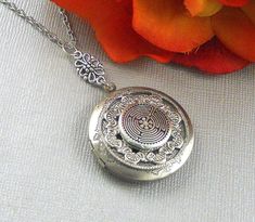 This enchanted locket is 28 inches long. Antique finished round silver locket has beautiful engraved floral patterns on the sides. I have set a antique silver finished Victorian inspired ornament which is embellish with pewter Labyrinth Celtic embellishment. Pendant is finished with silver floral connector, antique silver metal chain, and lobster clasp.. Locket is 32mm in size. It has room for two photos inside! Please note: I DO NOT DO ENGRAVING OR INSERT PICTURES! Thanks for looking:) Mani Antique Silver Jewelry With Compass Design, Spiritual Nickel-free Locket Necklace, Bohemian Silver Locket Necklace With Round Pendant, Silver Bohemian Engraved Locket Necklace, Bohemian Engraved Round Locket Necklace, Engraved Spiritual Locket Necklace Adjustable, Adjustable Engraved Spiritual Locket Necklace, Silver Spiritual Locket Necklace, Bohemian Silver Locket Necklace