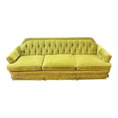 a green couch with two pillows on it's back and the seat upholstered