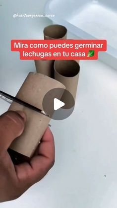 a person is holding some toilet paper and using scissors to cut the ends off it