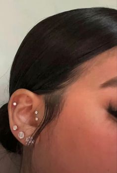 a close up of a person with ear piercings on their ears and one behind her head