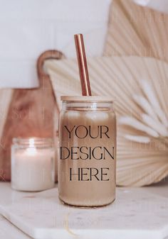 a jar with a straw in it sitting on a table next to a candle and an umbrella