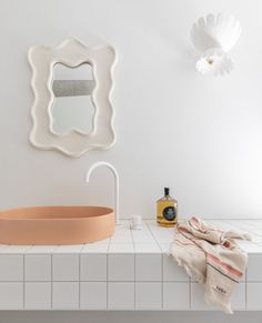 a bathroom with a sink, mirror and towel on the counter