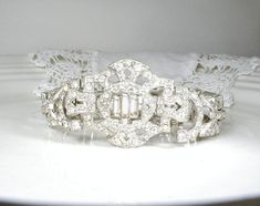 "Offering a beyond stunning vintage Art Deco pave crystal rhinestone wide link/panel flapper bracelet perfect for the Bride! Photos don't begin to do it justice or capture the unbelievable sparkle adequately! Bracelet measures a hair under 7 1/8 inches (18.1 cm) when clasped and is 1 1/8 inch (2.9 cm) wide at the center. These extra wide link Deco bracelets are getting harder and harder to find and this one is exquisite! The geometric silver pot metal bracelet is made up of ornate openwork links 1920's Wedding, Bride Photos, Vintage Rhinestone Jewelry, Bridal Jewelry Vintage, Wedding Silver, Metal Bracelet, Rhinestone Bracelet, Rhinestone Jewelry, Antique Art Deco