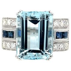 Art Deco style ring set in the center with a stunning Aquamarine weighing 11,54 carats graded AAA, and surrounded by approx. 0.50 carat of custom cut Sapphires and 0.65 ct of round brilliant cut diamonds graded G Color Vvs Clarity, Remarkable gallerias work. Circa 1940 CONDITION: Pre-owned - Excellent METAL: 18k gold GEM STONE: Aquamarine 11,54 ct - Sapphire ct 0,50 - Diamond 0.65 ct RING SIZE: US 7/7,5 - IT 15 - FR 55- UK O, Resizable on request, free of charge GROSS WEIGHT: 10,25 grams * every jewel we propose for sale is professionally tested by our internal gemological team of specialist I.G.I./HRD - ** the jewel comes with Gemological appraisal and warranty in a nice ring box For any further information or enquires please don't hesitate to contact us Sapphire Gold Ring, Emerald Cut Rings, Art Deco Stil, Estilo Art Deco, Deco Jewelry, Diamond Rings Bands, Gem Stone, Art Deco Style, Round Brilliant Cut Diamond