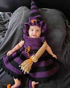 a baby dressed in a purple and black crochet costume with a witch hat