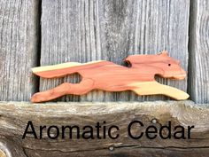 a wooden carving of a cat on top of a piece of wood with the words aromaic cedar above it