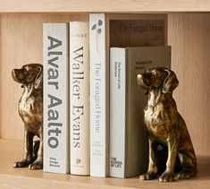 two bookends with dog figurines next to each other on a shelf