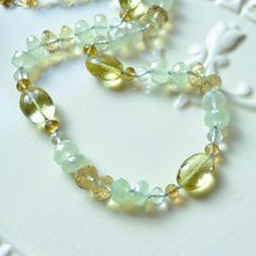 "This luxe gemstone necklace is a stunning piece of jewellery that you will treasure forever. Over four dozen sparkly beads are strung onto light blue silk cord, creating a stunning necklace of subtle colours. A tiny knot separates each stone, which results in a beautiful drape. The stones are about 4mm - 12mm in size, and contain lemon quartz in two shades of yellow, pale green amethyst, rich beer quartz, and mystic green chalcedony. This colour combination is unexpected and so pretty. A small Luxury Adjustable Hand Knotted Necklaces, Luxury Amethyst Necklaces With Natural Stones, Luxury Amethyst Necklace With Natural Stones, Luxury Amber Necklaces For Anniversary, Luxury Amber Necklace For Anniversary, Luxury Gemstone Beaded Necklaces For Jewelry Making, Luxury Amethyst Gemstone Beads Jewelry, Elegant Amber Crystal Necklaces With Round Beads, Luxury Gemstone Beads Jewelry For Healing