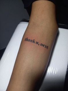 a person with a tattoo on their arm that says thank you next in black ink