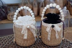 two baskets with white pearls on them sitting on top of a table next to each other