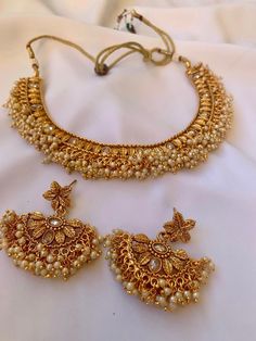 Step into an era of timeless elegance with our Antique Gold Choker Necklace and Earrings set, beautifully crafted to embody the essence of traditional Desi jewelry. Adorned with exquisite white pearls and intricate leaf designs, this set has a graceful allure that embodies vintage charm. Each piece is delicately embellished with sparkling Kundan stones, adding a dazzling touch to your ensemble. Whether you're adorning it for an Indian, Pakistani, or Desi occasion, this set promises to elevate your style with its regal aesthetic. Embrace tradition while making a statement of sophistication with this stunning jewelry set. Desi Jewelry, Leaf Designs, Gold Choker Necklace, Leaf Jewelry, Gold Choker, Wedding Jewellery Necklace, Earrings White, Stunning Jewellery, Stylish Jewelry