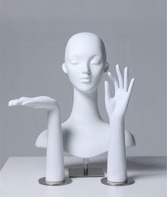 a white mannequin with two hands on it's head and one hand in the air