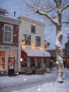 the outside of a restaurant with snow falling on it