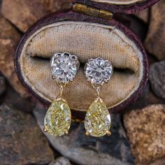 This lovely pair of dangle earring are each accented with one (1) pear modified brilliant cut fancy yellow colored diamond set into a three-prong setting and one (1) round brilliant cut diamond set into a platinum four- prong setting. The earrings are finished with platinum friction backs and posts for pierced ears. Yellow Diamond Earrings, Yellow Diamond Earring, Pear Diamond Rings, Peridot Jewelry, Fancy Yellow Diamond, Pear Cut Diamond, Diamond Dangle Earrings, Diamond Drop Earrings, Diamond Drops