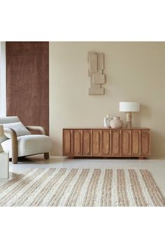 a living room scene with focus on the sideboard and chair in the foreground