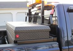 the back of a truck with luggage on it's flatbed in front of a house