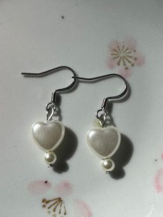 ♡ Trendy heart earrings handmade with faux pearls and linked with stainless steel wire. ♡ Tarnish free and made to last (with proper care). ♡ Choose between the 3 heart style or 1 heart style. ♡ Silver stainless steel and gold plated stainless steel options available. White Metal Earrings For Valentine's Day, Silver Pearl Earrings For Valentine's Day, Valentine's Day White Metal Earrings, Metal Heart Earrings For Wedding, Heart Beads Metal Earrings For Gift, Metal Heart Beads Earrings For Gifts, Metal Heart Beaded Earrings For Gifts, White Dangle Heart Earrings With Ear Wire, Heart-shaped Metal Earrings For Wedding