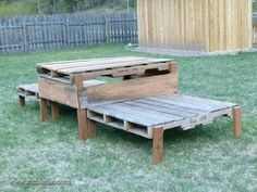 a wooden bench made out of pallets sitting in the grass