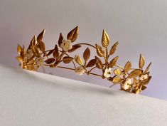 A beautiful simply elegant leaf headband. Slightly raised tiara style. Loops of gold gold delicate golden leaves, tapering from the centre.  Optional hand-carved mother of pearl flowers, which catch the light to give a gentle pearlescent shimmer. Leaves are organically placed (non-symmetrical but balanced). Headband is very light and the ends can be gently bent out to fit a larger head if necessary (I can do this for you before shipping if you prefer. Gold Leaf Crown, Leaf Headband, Tiara Headpieces, Leaf Crown, Pearl Flowers, Leaves Headband, Hair Wreaths, Crown Tiara, Feuille D'or