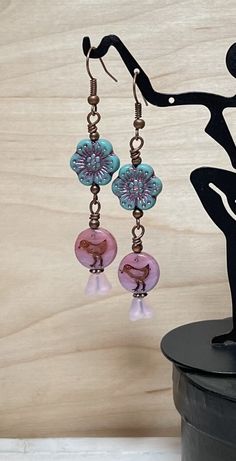 Adorable boho dangle earrings perfect for spring and summer! These are created using Czech glass wild rose flower beads in deep turquoise with a pink wash, Czech glass bird coin beads in shades of pink, and semi-transparent matte pink Czech bell flower beads.  Perfect for everyday, and make a lovely gift!  Total length of earrings, including the ear wire, is approximately 2-1/2".    Thank you for shopping with The Lucie Collection! Handmade Bohemian Jewelry For Spring, Whimsical Spring Earrings, Whimsical Spring Earrings For Pierced Ears, Adjustable Bohemian Flower Earrings, Adjustable Bohemian Drop Flower Earrings, Bohemian Dangle Flower Earrings For Pierced Ears, Bohemian Flower Earrings For Beach Spring, Bohemian Spring Flower Earrings For Beach, Spring Bohemian Flower Earrings For Beach