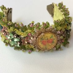 a close up of a bracelet with flowers on it