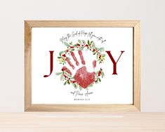 a wooden frame with a red handprint on it and the words, joy written in cursive writing