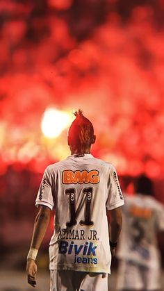 a baseball player standing in front of a red sky with flames behind him and the number 11 on his jersey