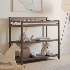 a baby crib with stuffed animals on it in a room next to a lamp